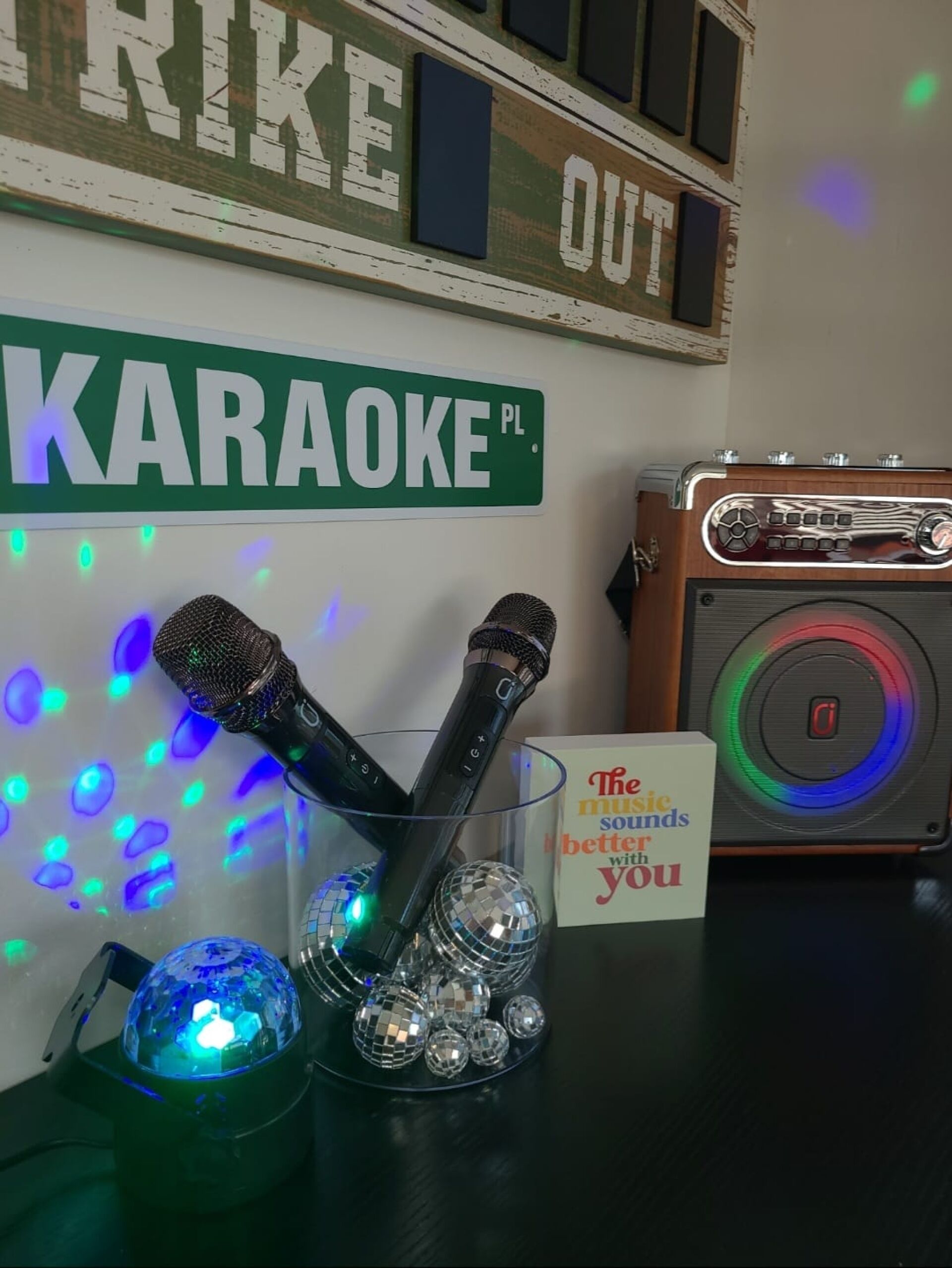 Un equipo de karaoke con micrófonos, bolas de discoteca y una radio antigua.