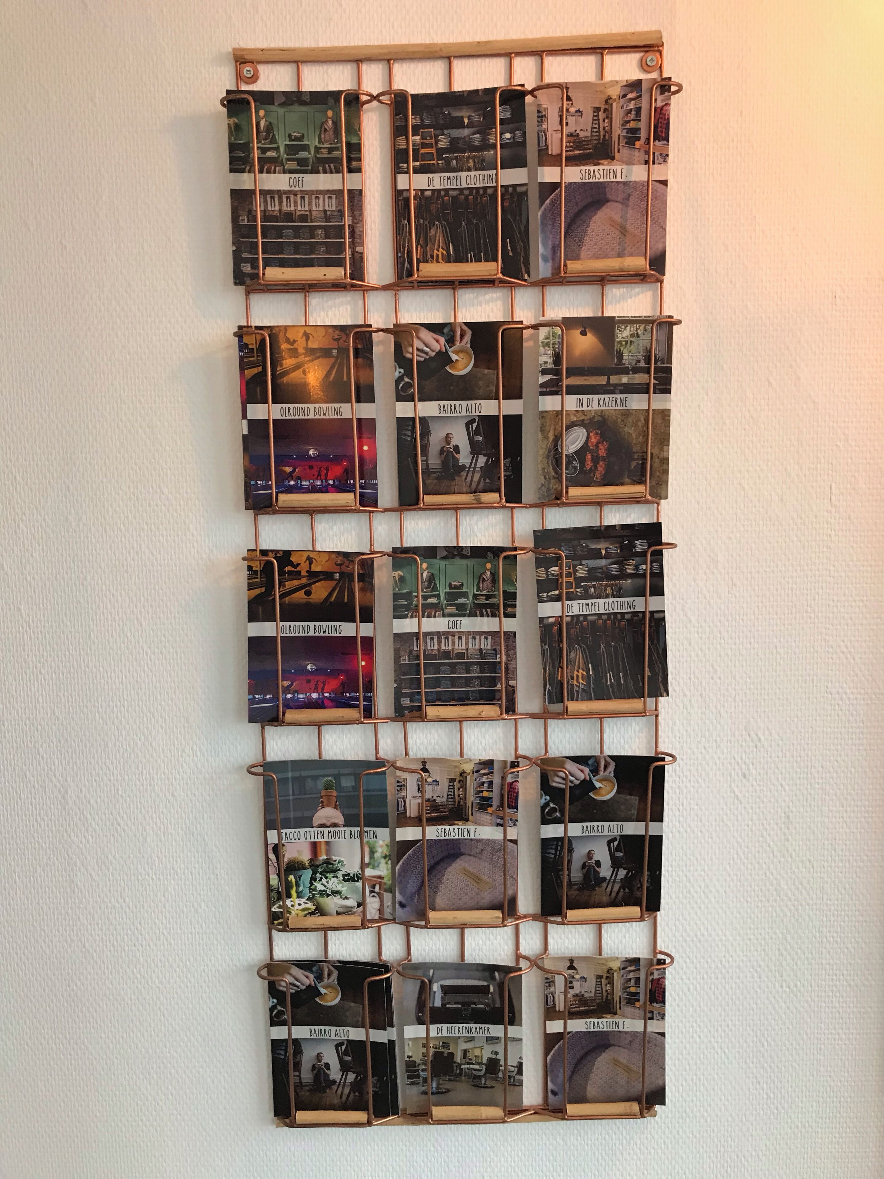 A wall-mounted display of vintage photographs with labels, likely representing historical locations or events.