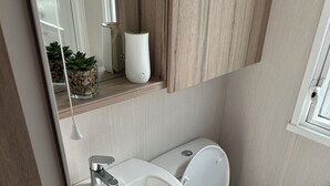 Ein modernes Badezimmer mit Waschbecken, Toilette und einem kleinen Fenster.