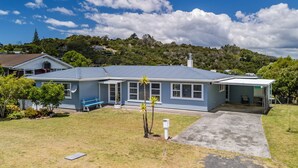A single-story house with a blue exterior, a front porch, and a small front yard. - Retro Russell Retreat - Mins to Ferry, Beach, Eats (Russell)