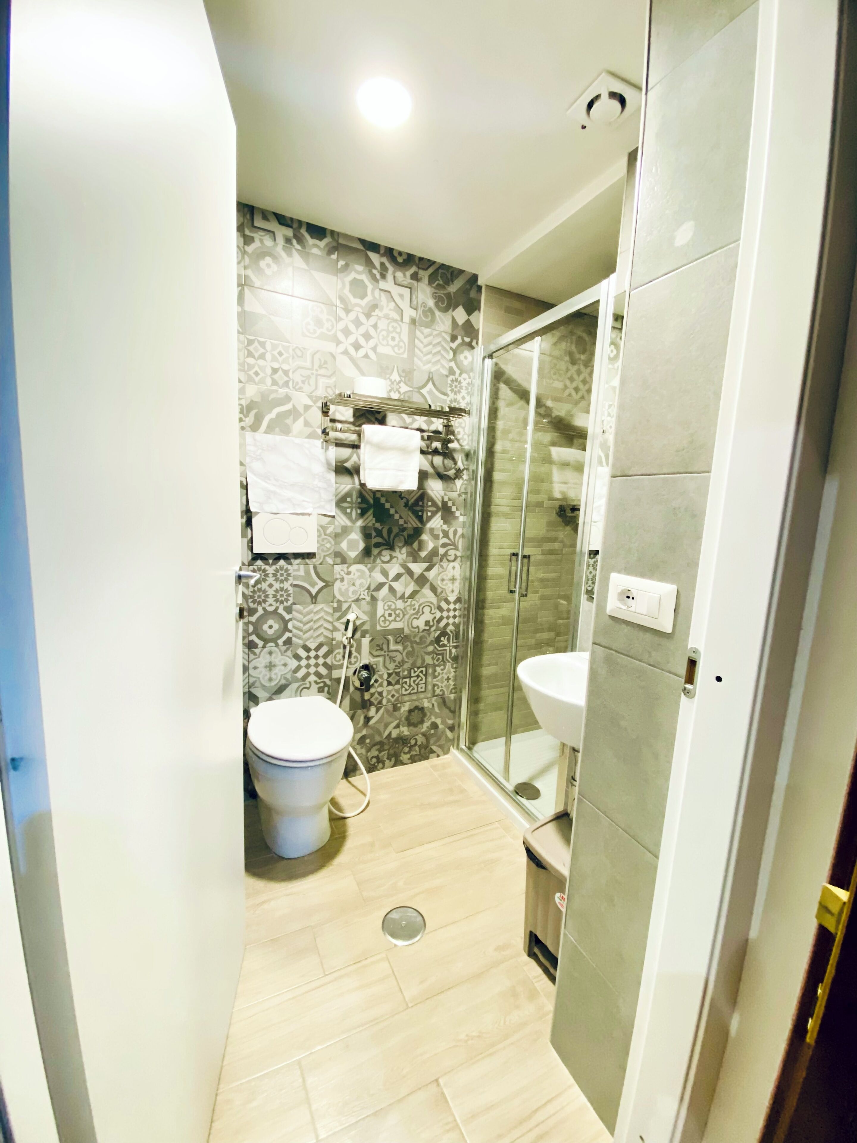 Une salle de bain moderne équipée de toilettes, d’un lavabo et d’une douche à parois de verre.