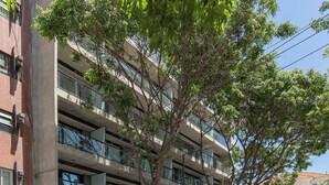 Eine mehrgeschossige Parkgarage mit einem Baum im Vordergrund.