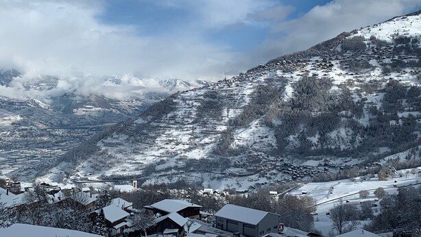 A snow-covered mountain village with traditional houses, a church, and a clear view of the surrounding peaks. - Remointze B 031 - CENTER studio 4 pers (Veysonnaz)