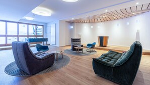 Een moderne loungehoek met zitplaatsen, een bijzettafeltje en uitzicht op de omgeving.