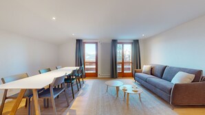 Un salon moderne avec une table à manger, un canapé et une vue sur l’extérieur.