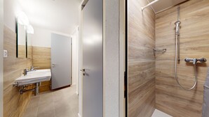 Une salle de bain moderne avec une douche, un lavabo et un miroir.