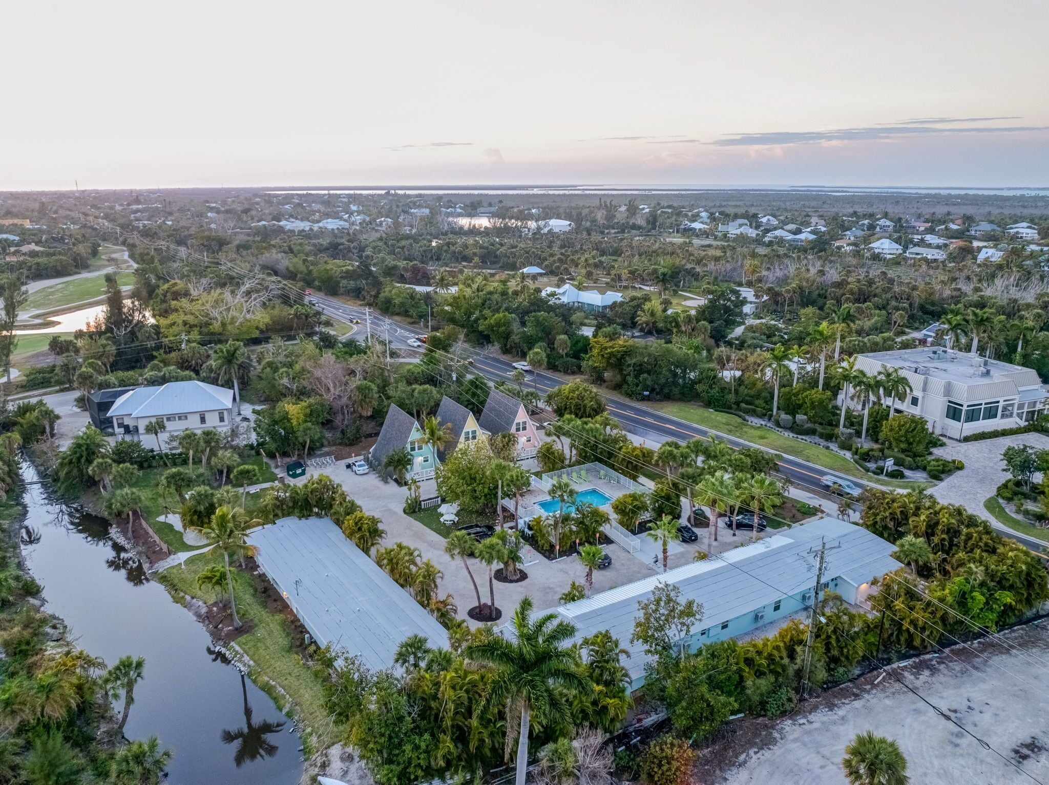 An aerial view of a residential area with houses, roads, and a body of water.
