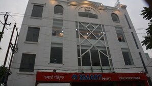 A building with a large glass facade and a sign reading "SMART POINT DELIVERY POINT".