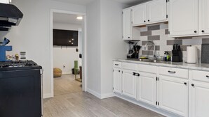 Una cocina moderna con armarios blancos, una estufa negra y un salpicadero de azulejos.