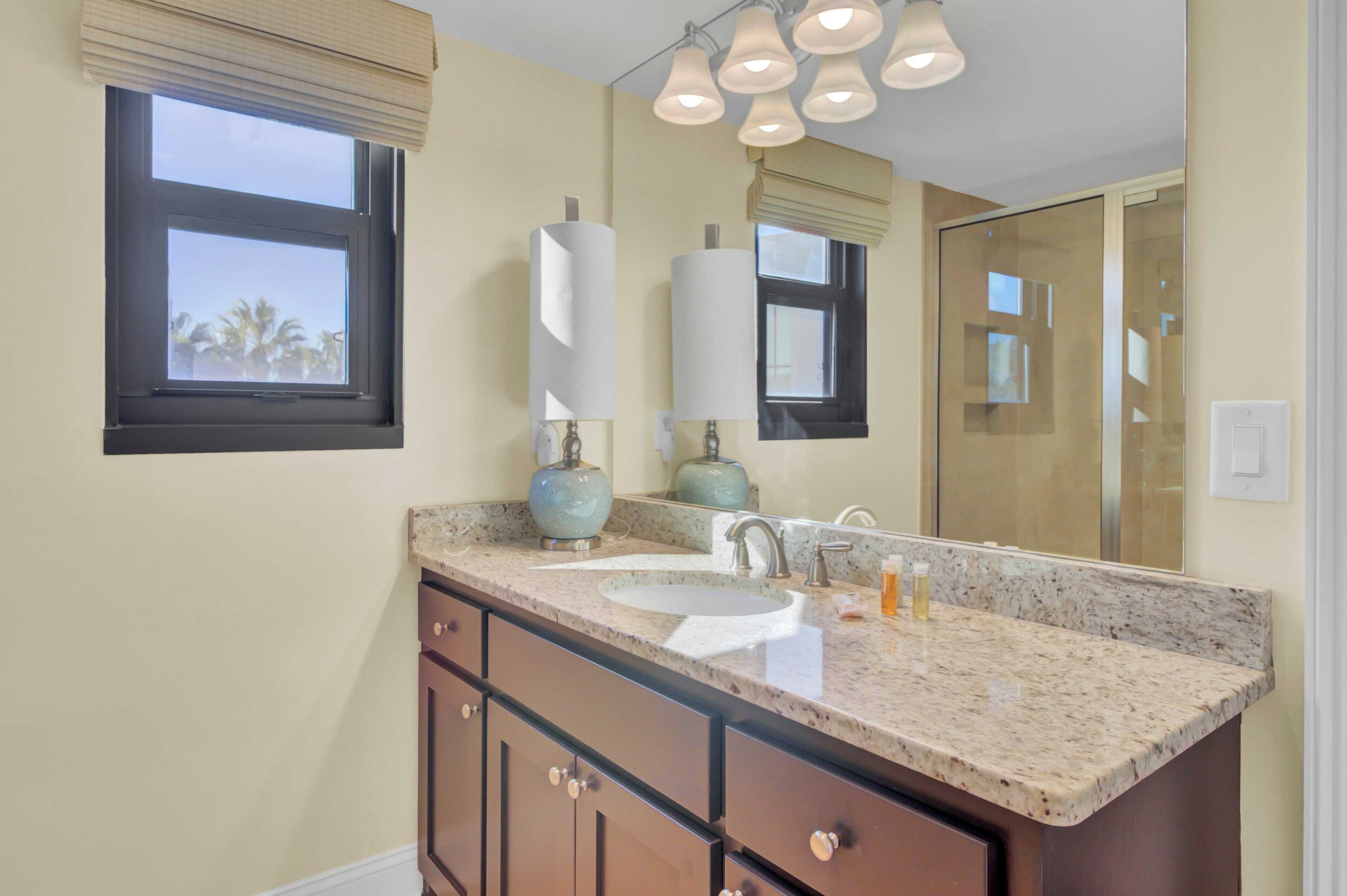 A bathroom with a double sink, vanity, and a large mirror.