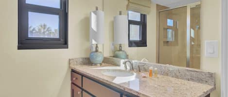 A bathroom with a double sink, vanity, and a large mirror.