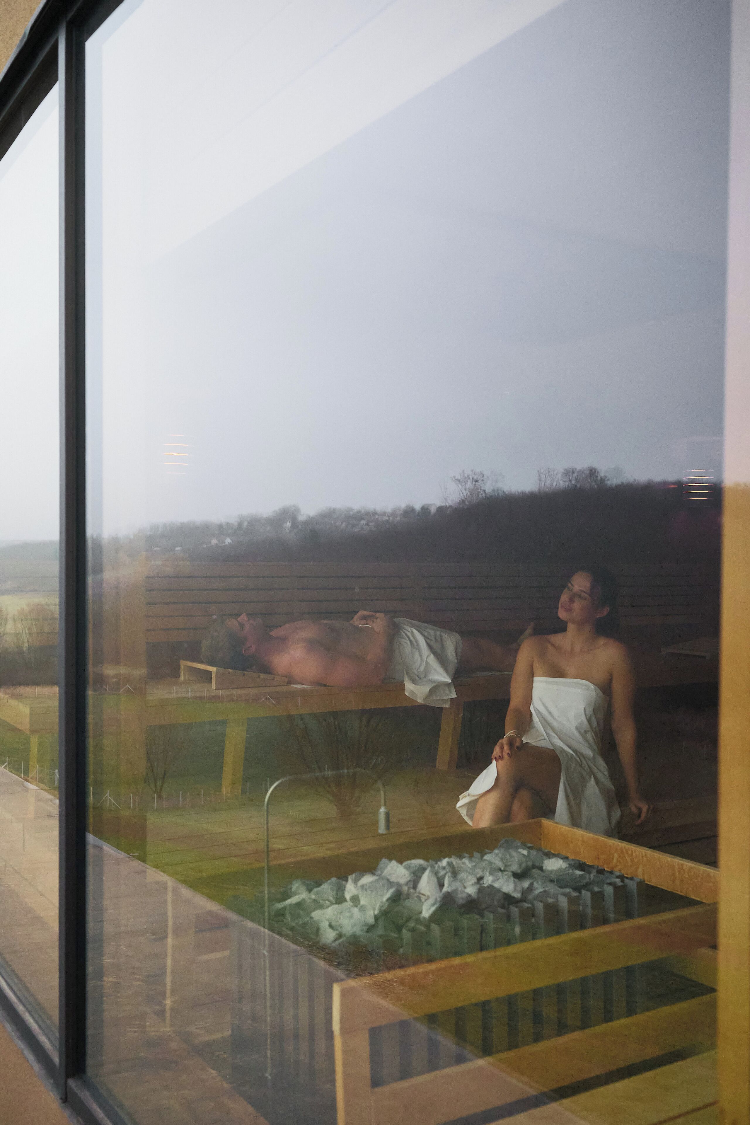 Un área de spa con un banco de madera y una persona sentada.