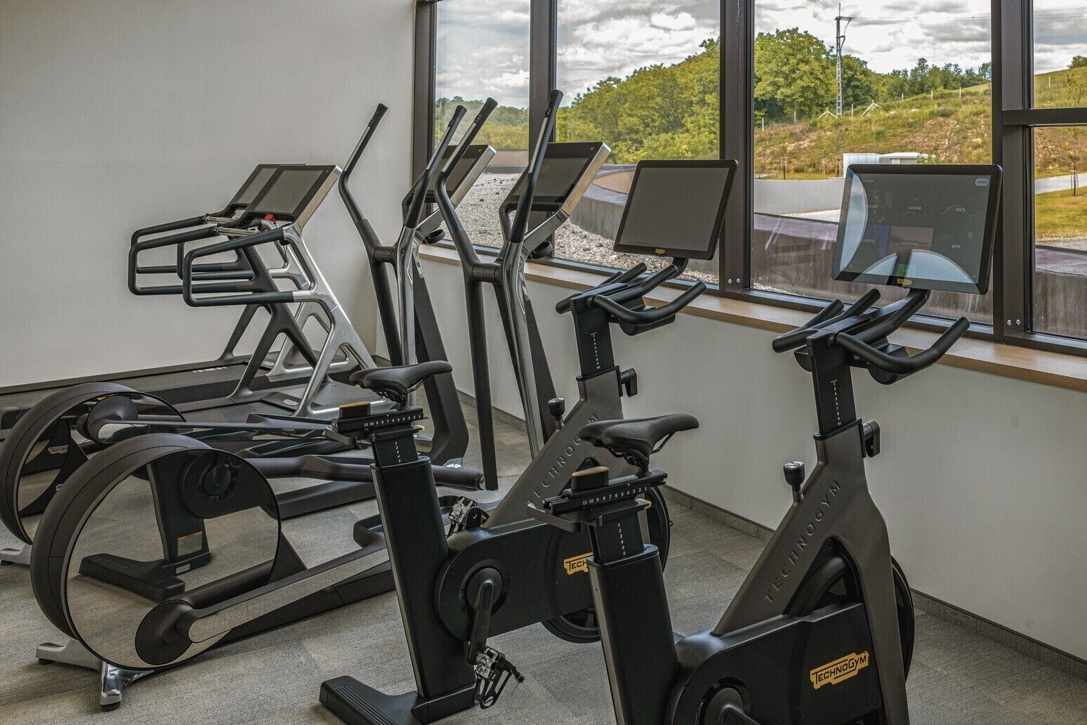 A gym with treadmills, stationary bikes, and a rowing machine.