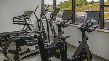 A gym with treadmills, stationary bikes, and a rowing machine.