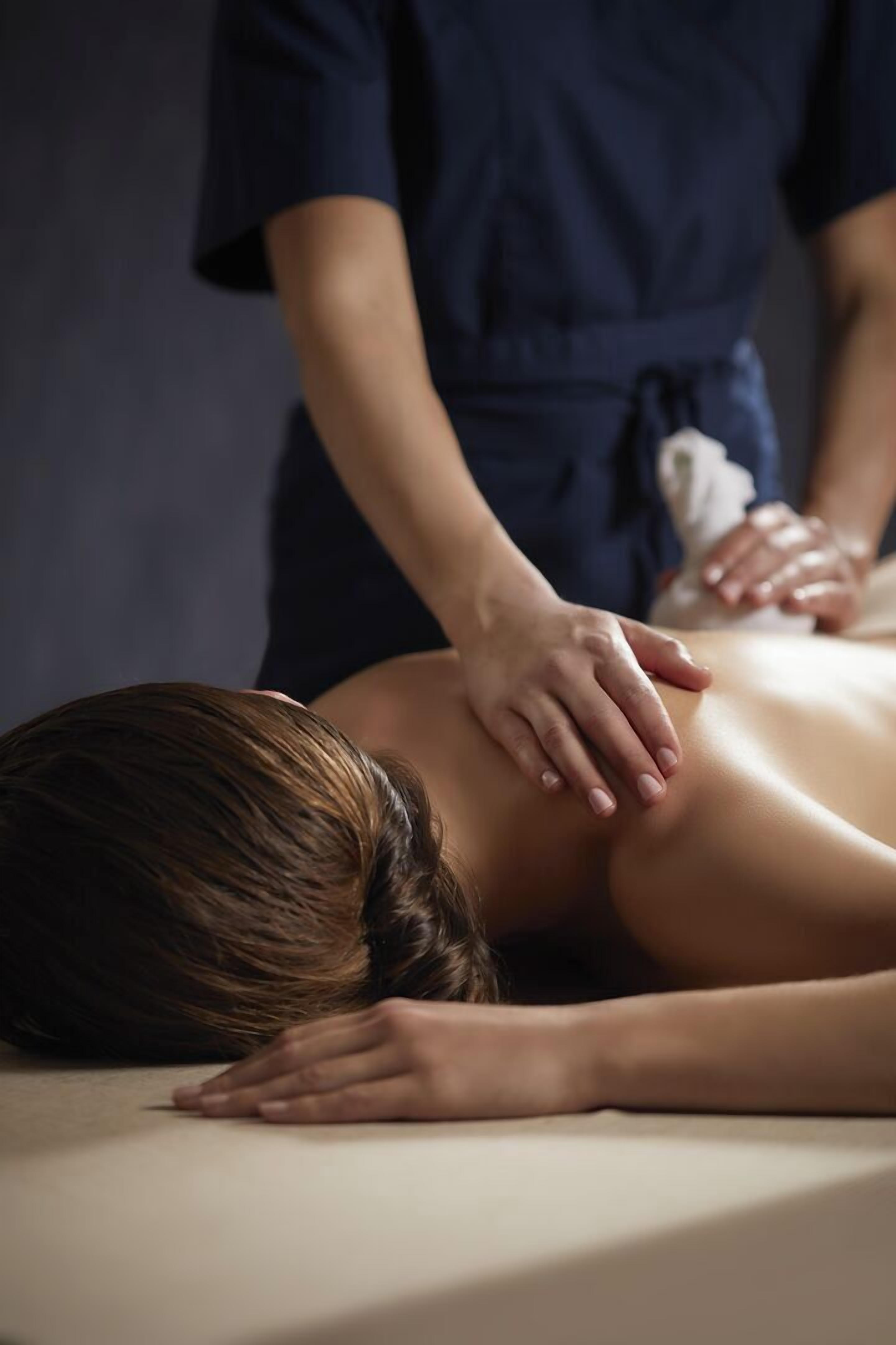 Een persoon ontvangt een massage op een massagetafel.
