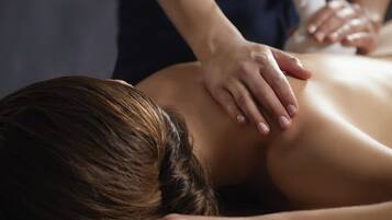 Een persoon ontvangt een massage op een massagetafel.