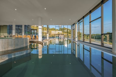 Una piscina techada, sillones reclinables de piscina. Hotel Essence