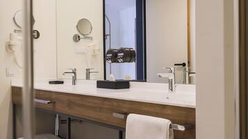A modern bathroom with a double sink vanity, a towel rack, and a mirror.