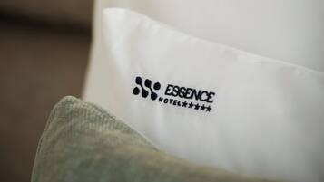 Ein Kissen mit dem Logo und dem Namen des Essence Hotels.