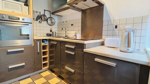 Moderni keittiö, jossa on ruostumattomasta teräksestä valmistetut kodinkoneet, mikroaaltouuni ja leivänpaahdin.