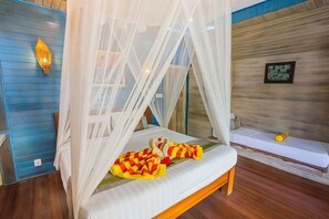 A room with a bed under a canopy, a bench, and a wall-mounted light fixture. - Nanuk's Bungalows (Bali)