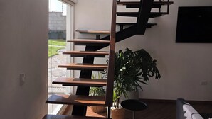 Een modern interieur met een houten trap, een potplant en een bank.
