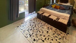 A bedroom with a large bed, a chandelier, a television, and a view of the outside.