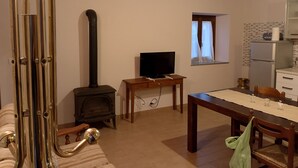 Un salon confortable avec une cheminée, un téléviseur et un coin repas.