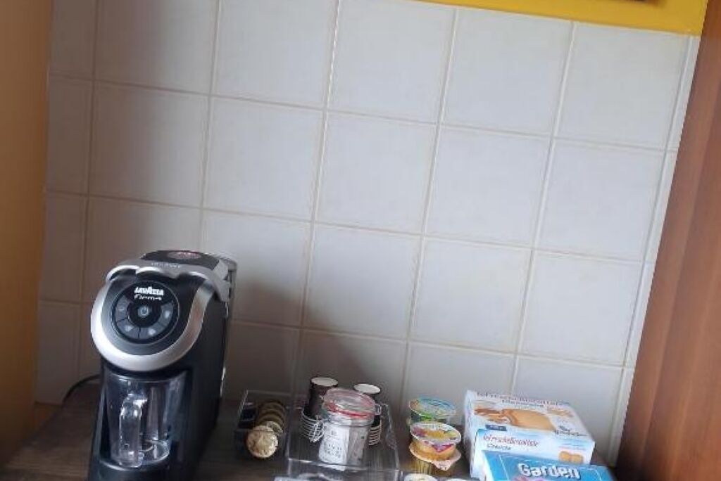 Un coin cuisine équipé d’une machine à café, de bocaux et d’aliments emballés.