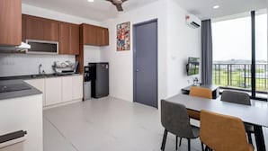 A modern kitchen with wooden cabinets, a built-in microwave, and a ceiling fan. - Apartments @ Podium Kuching (Kuching)