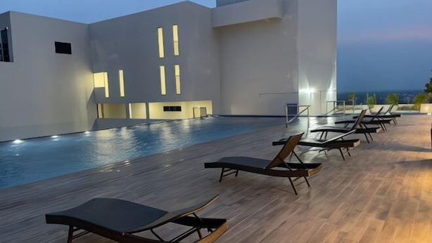 A modern pool area with sun loungers and a view of the ocean. - Apartments @ Podium Kuching (Kuching)