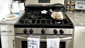 A kitchen with a stainless steel range hood, a stove with a kettle, and a coffee station. - Charmingly decorated , beautiful lagoon front beach house in Little Egg Harbor (Little Egg Harbor Township)