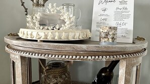 A vintage-style table with a tea set, a decorative pitcher, and a framed welcome sign. - Charmingly decorated , beautiful lagoon front beach house in Little Egg Harbor (Little Egg Harbor Township)