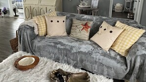 A cozy living room with a grey sofa, white furry rug, and a wooden bowl with a remote control. - Charmingly decorated , beautiful lagoon front beach house in Little Egg Harbor (Little Egg Harbor Township)