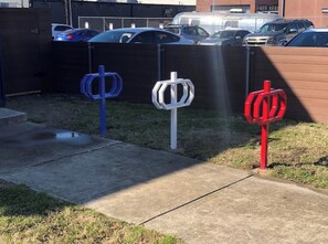 Park your vehicle in a designated area surrounded by unique bollards and lush greenery.