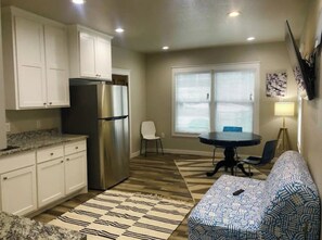Enjoy meals in the kitchen and dining area, featuring a central island, cabinetry, and a refrigerator.