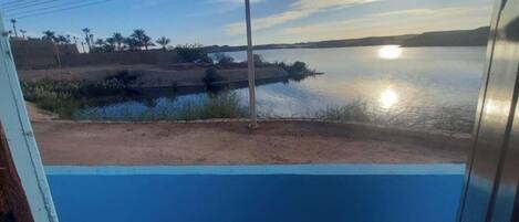 A view of a calm lake with a clear sky and a sunset.