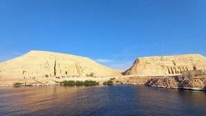 Zwei große Pyramiden mit einem Fluss im Vordergrund.