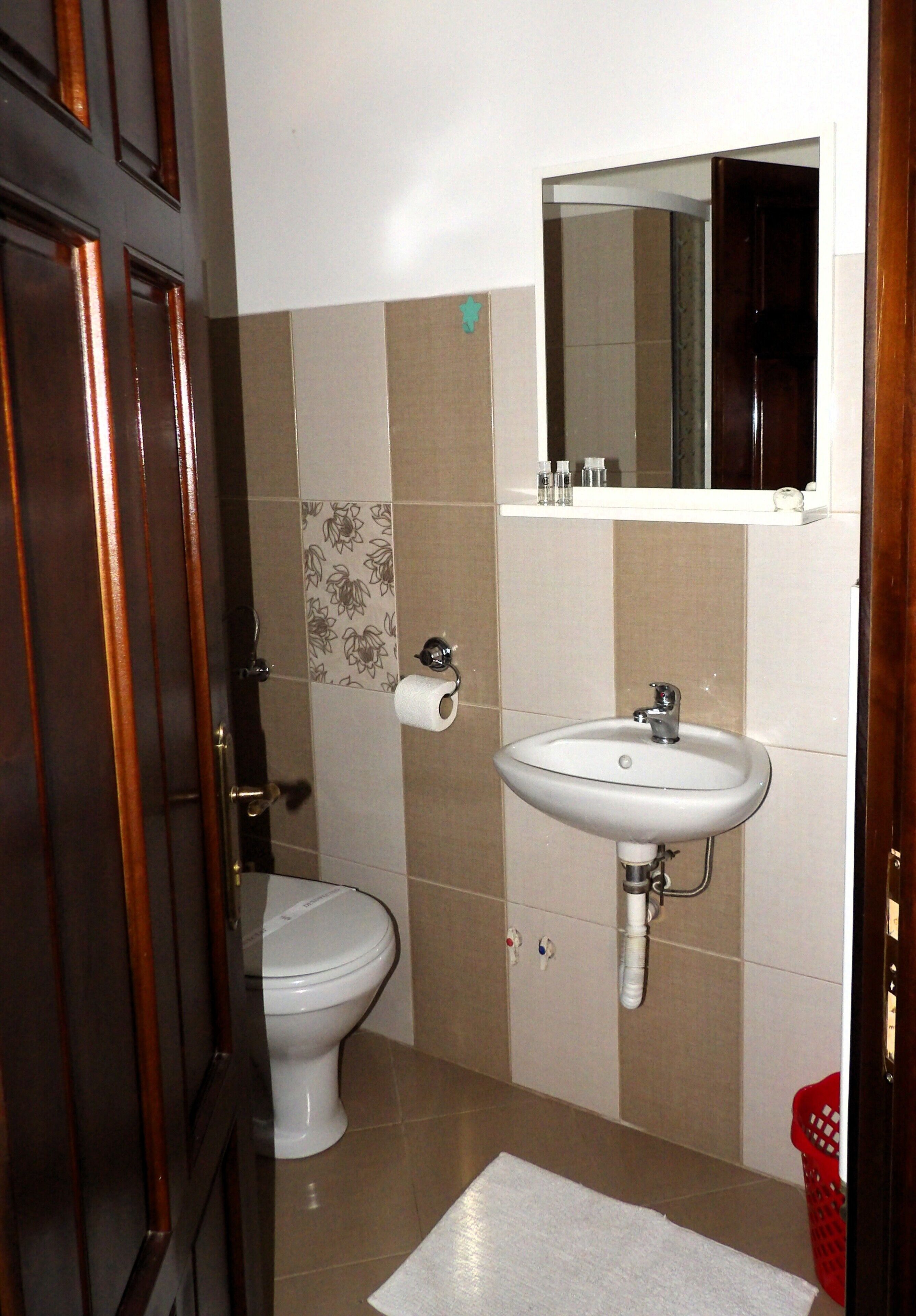 Un baño con inodoro, lavabo y espejo.