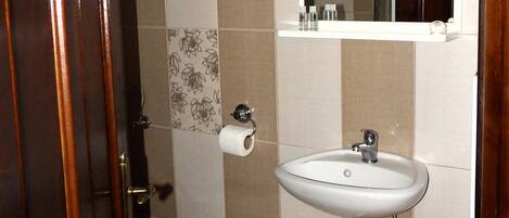 Un baño con inodoro, lavabo y espejo.