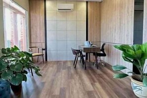 Un espace de bureau moderne avec un plancher en bois, une table entourée de chaises et des plantes en pot.