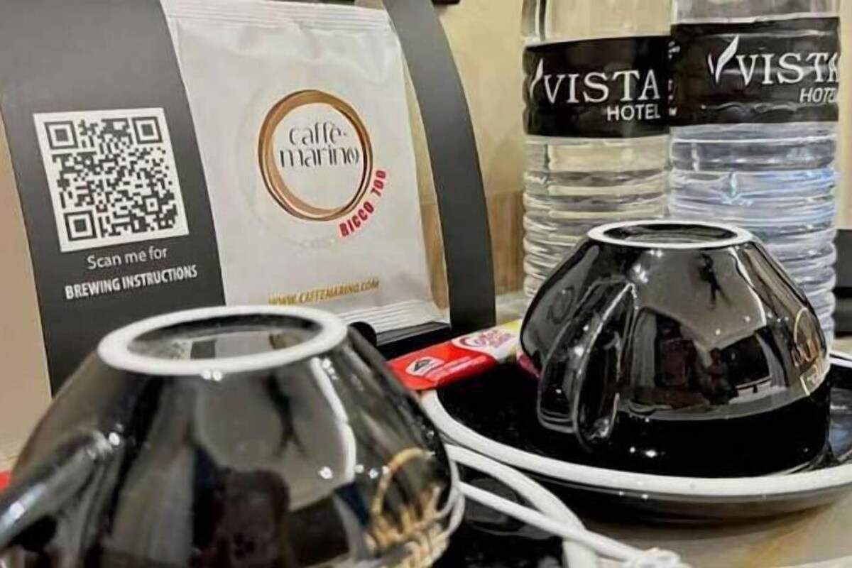 A coffee machine, a QR code for brewing instructions, and branded water bottles.