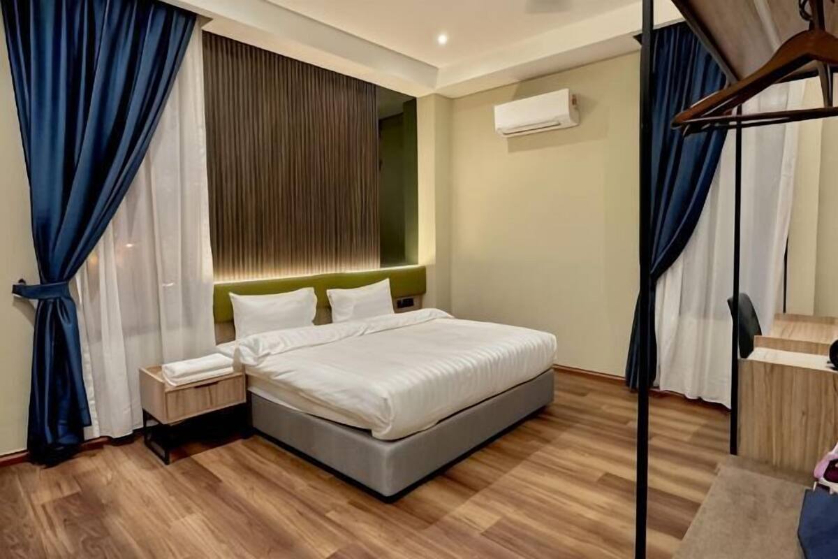 A bedroom with a bed, bedside tables, a wardrobe, and a mirror.