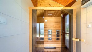 Een modern interieur met houten lambrisering, een glazen deur naar een andere kamer, en een zichtbaar raam.