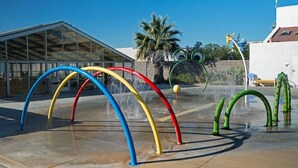 A water feature with colorful arches and a palm tree in the background. - 3BR Resort Oasis: Pools, Gym & Sunset Views (St. George)