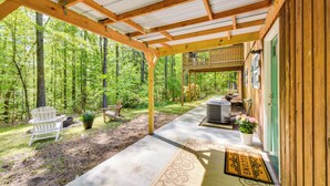 A covered porch with a wooden deck, a white chair, a potted plant, and a welcome mat. - 2 Mi to Toccoa Falls: Cozy Getaway w/ Yard! (Toccoa)