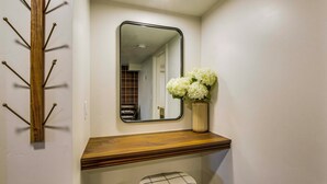 A bathroom with a wooden vanity, a mirror, and a white stool. - Scenic Patio & Views! Stay 10 Mi to Nordic Valley (Ogden)