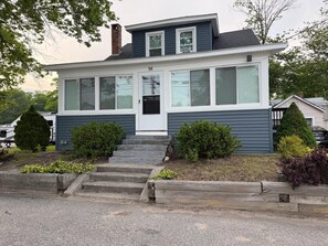 A two-story house with a front porch, a chimney, and a mailbox.