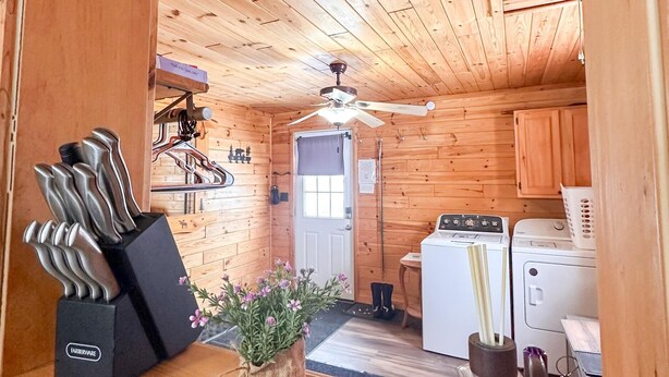 A wooden cabin interior with a kitchen area, a ceiling fan, and a sink.
