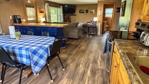A spacious living area with a kitchen, dining table, and seating.